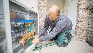 Craftsman connects the underfloor heating pipes to the manifold