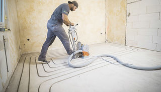 Craftsman cuts channels in the screed with a milling machine